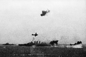 Le bâtiment HMAS Australia attaqué par des avions japonais lors de la Bataille de la Mer de Corail. [Australian War Memorial: ID Number 044238]
