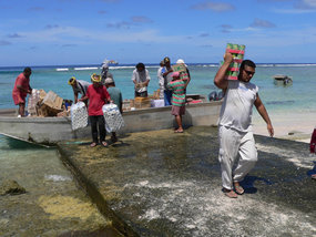 Des villageois de Nukunonu, l'un des trois atolls de Tokelau, déchargent un bateau de ravitaillement venu de Nouvelle-Zélande. Tokelau, territoire néo-zélandais, a obtenu récemment son propre drapeau. [Source non identifiée]